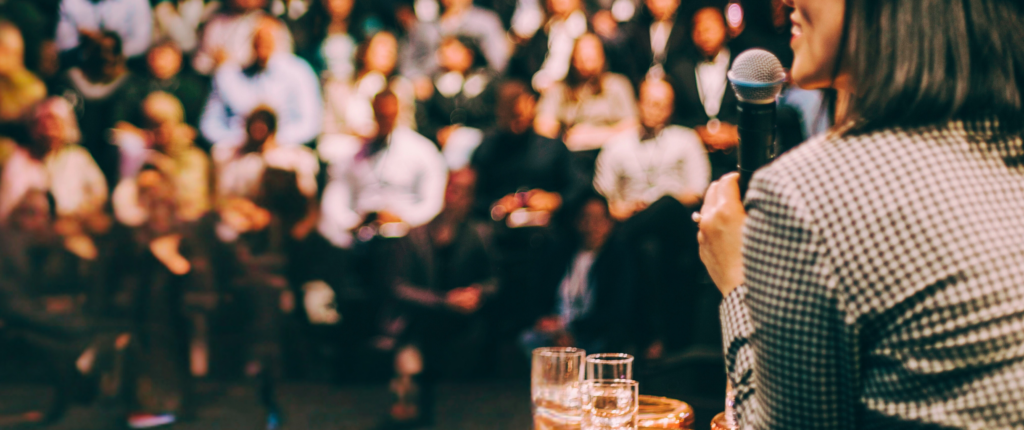 woman with a microphone speaking to audience